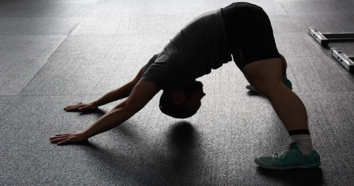 A man stretching in a gym.