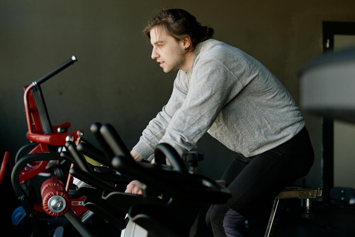 A man riding on an exercise bike in a gym.