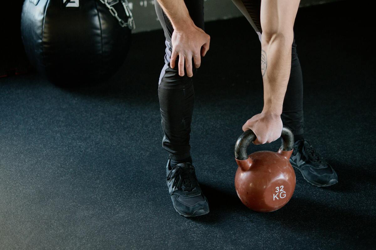 A person doing kettlebell exercises in a gym.