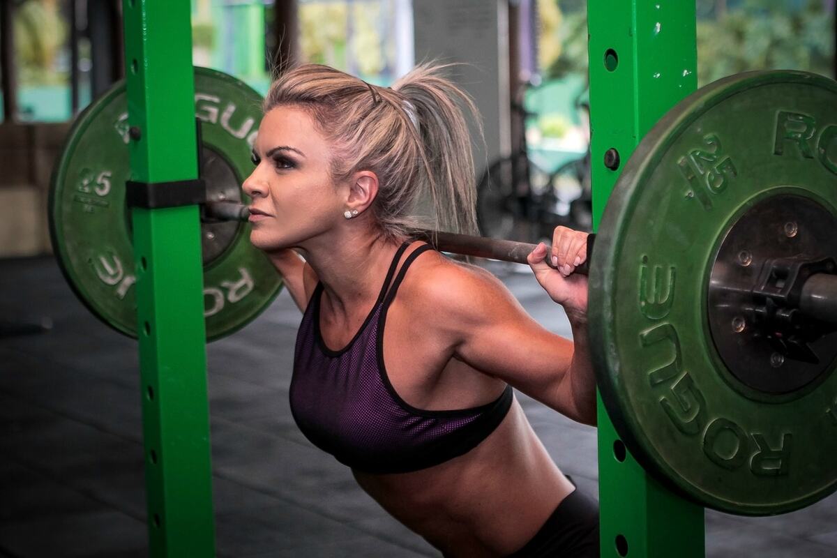 A woman lifting weights in a gym.