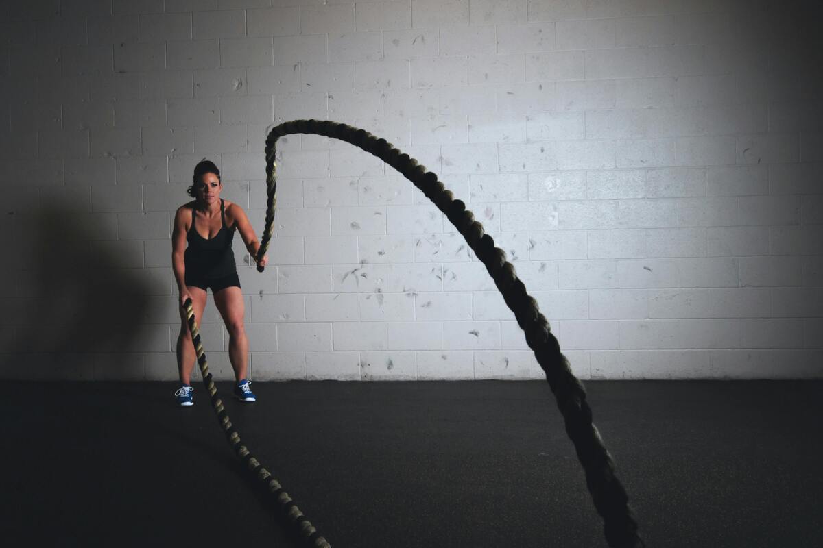 A woman doing battle rope exercises.