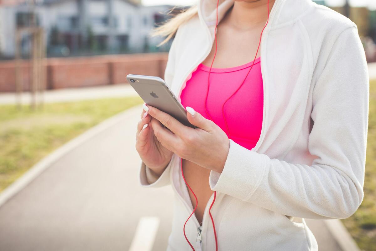 A woman preparing music on her phone for a jog.