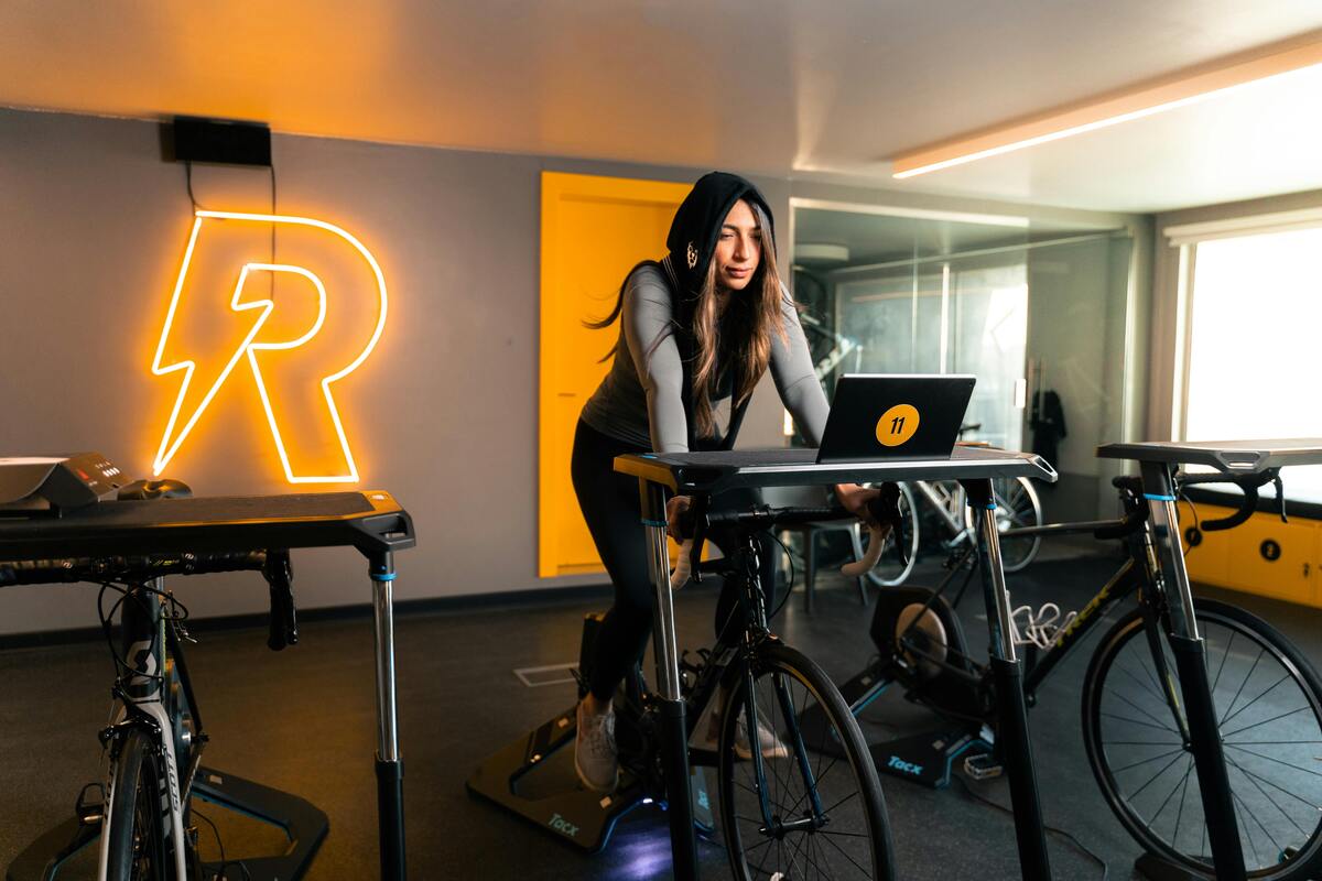 A woman training on one of the best cardio machines for fat loss - an exercise bike.